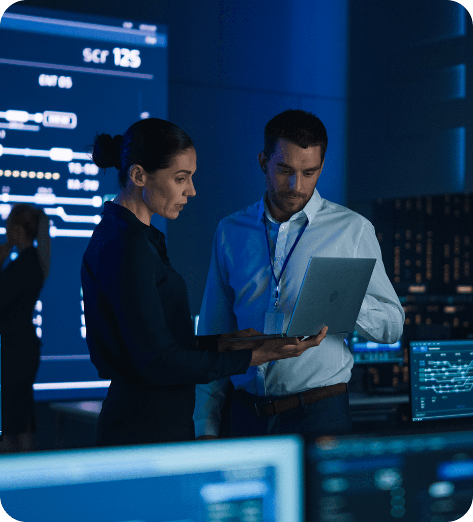 Two professionals analyzing data on a laptop.